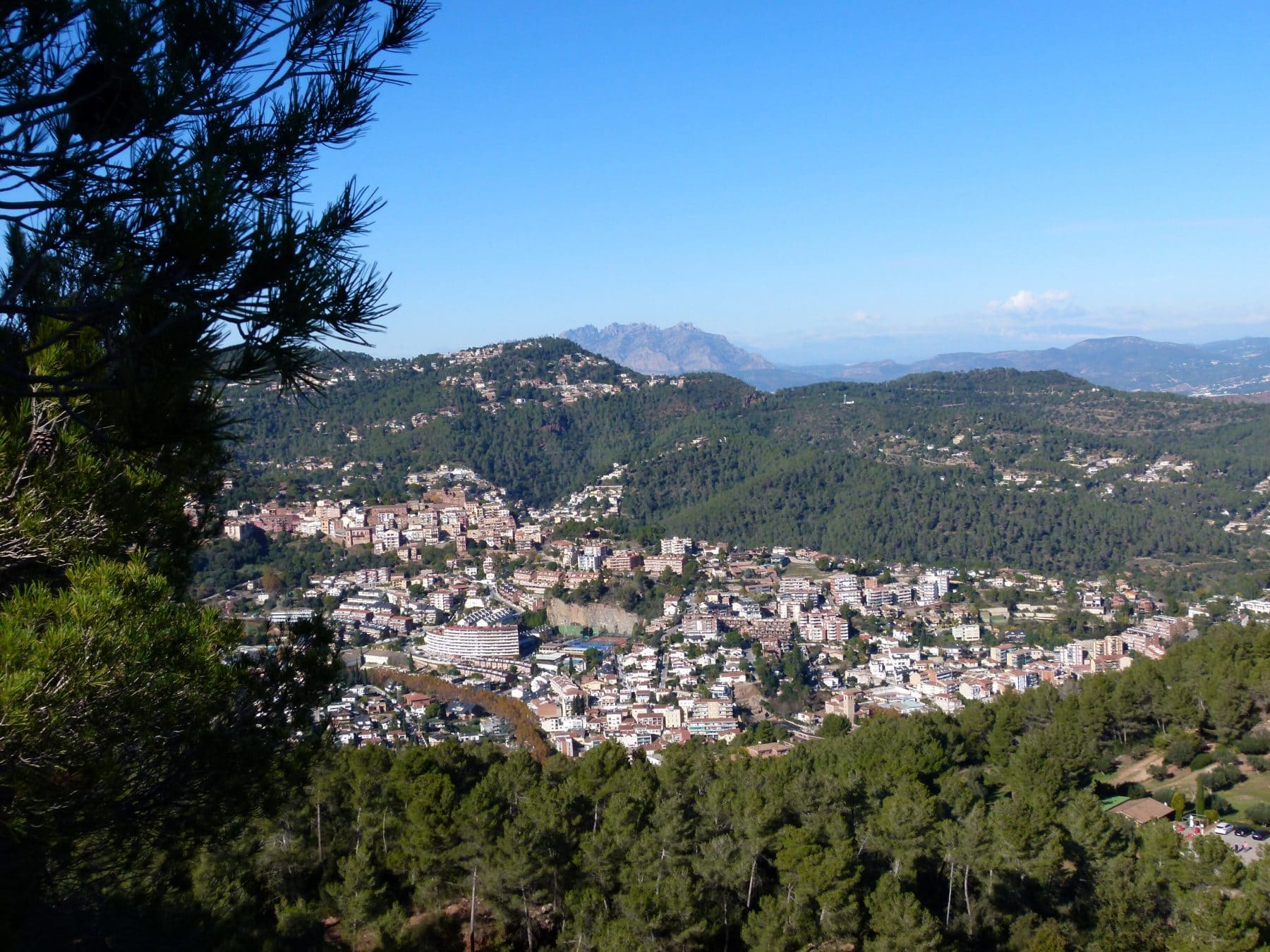 Vista general de Corbera de Llobregat entre pinares, con Montserrat al fondo