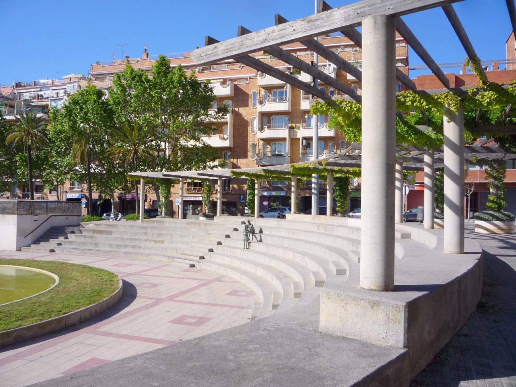 Plaça de Catalunya de Esplugues de Llobregat, con su graderío semicircular y la pérgola en un día soleado